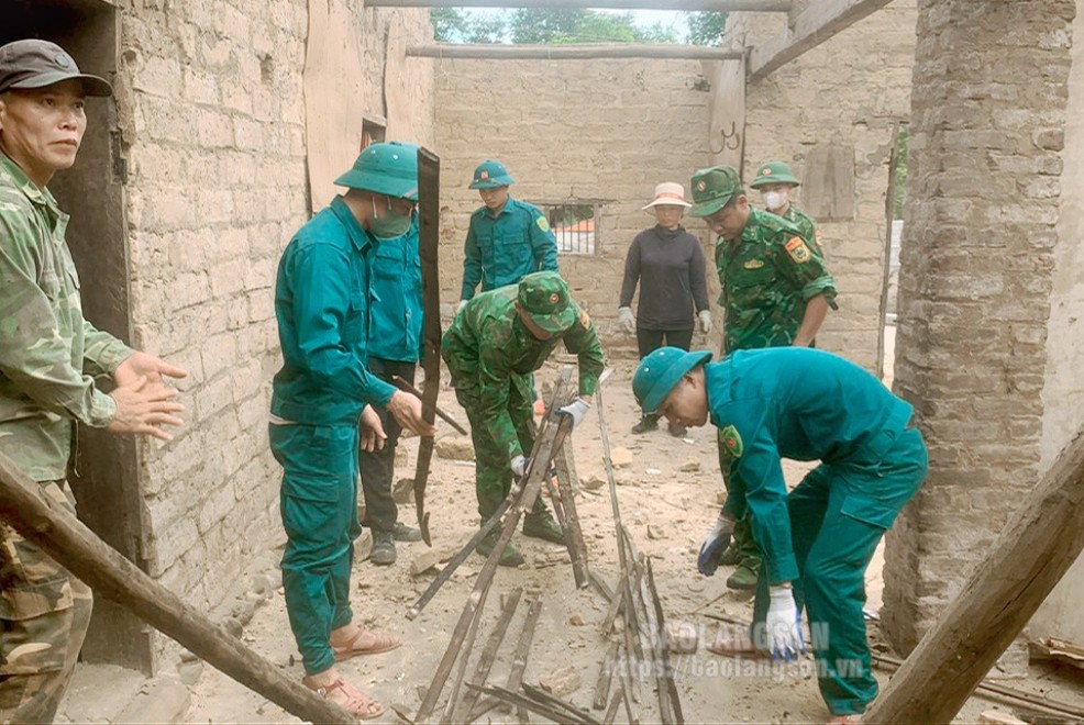 Cán bộ, chiến sĩ Đồn Biên phòng Na Hình và lực lượng dân quân xã Thụy Hùng giúp đỡ gia đình bà Lăng Thị Hộ dỡ ngôi nhà cũ, tạo mặt bằng xây dựng nhà mới