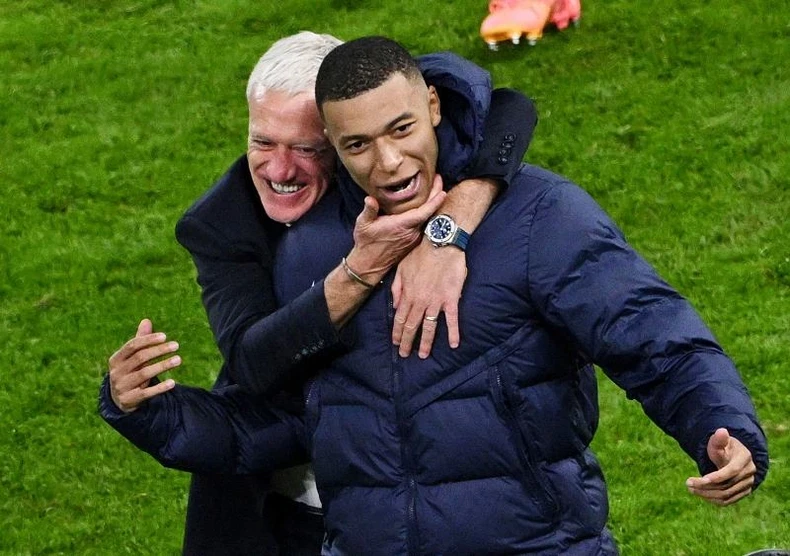 HLV Didier Deschamps ăn mừng cùng Kylian Mbappé sau khi giành chiến thắng trong loạt sút luân lưu. (Ảnh: Reuters)