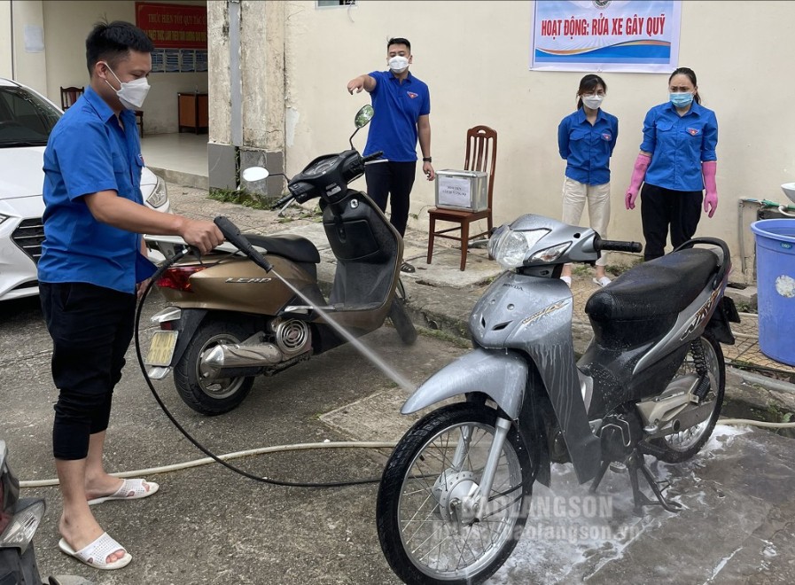 Thanh niên Chi đoàn Trung tâm Kiểm soát bệnh tật tỉnh triển khai hoạt động rửa xe gây quỹ  Ảnh :  HOÀNG VƯƠNG