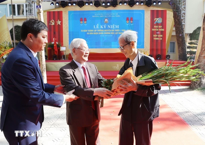 Tổng Bí thư Nguyễn Phú Trọng, cựu học sinh Trường THPT Nguyễn Gia Thiều, tặng hoa chúc mừng nhà giáo Lê Đức Giảng, nguyên Bí thư Chi bộ, Giáo viên chủ nhiệm lớp 10B Trường Nguyễn Gia Thiều gần 60 năm về trước. (Ảnh: Trí Dũng/TTXVN)