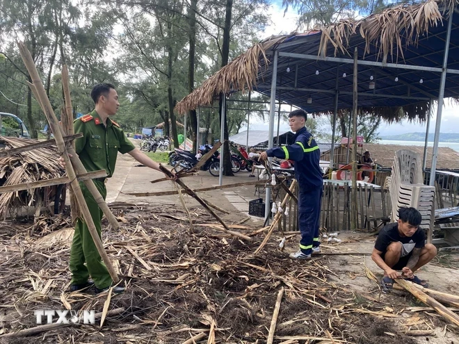 Lực lượng Công an, Cảnh sát huyện Cô Tô giúp người dân thu dọn sau cơn bão số 2. (Ảnh: Thu Báu/TTXVN phát)