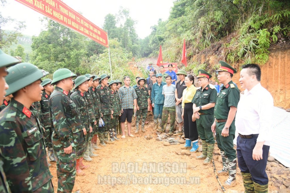 Các thành viên đoàn công tác thăm hỏi, động viên cán bộ, chiến sĩ và bà con tham gia làm đường