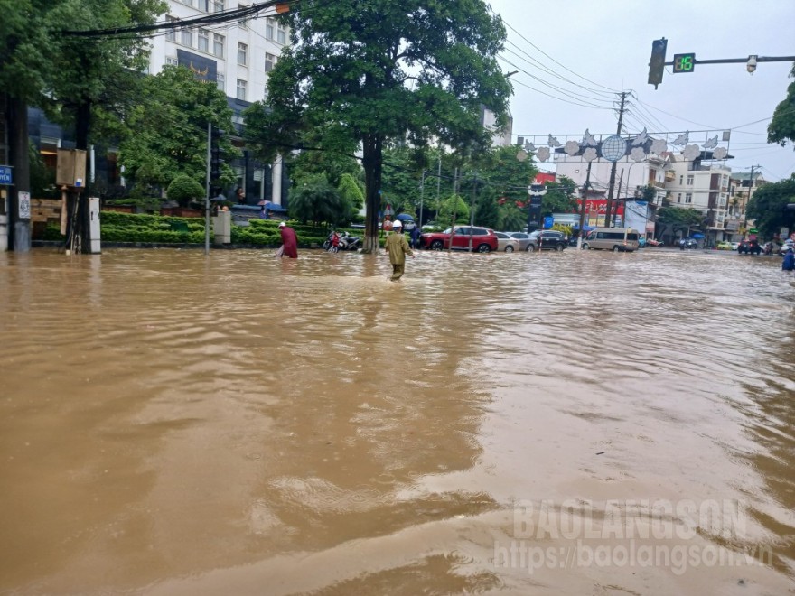 Lực lượng chức năng và người dân tìm cách khơi thông cống thoát nước khu vực giao cắt giữa đường Lê Đại Hành và đường Ngô Quyền, thành phố Lạng Sơn