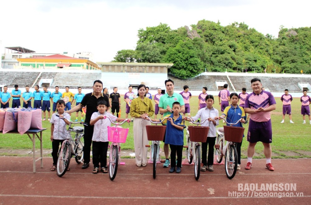 Đại diện Liên đoàn Bóng đá tỉnh và CLB Bóng đá nghệ sỹ V-Stars trao quà cho các học sinh nghèo vượt khó của xã Đồng Bục, huyện Lộc Bình