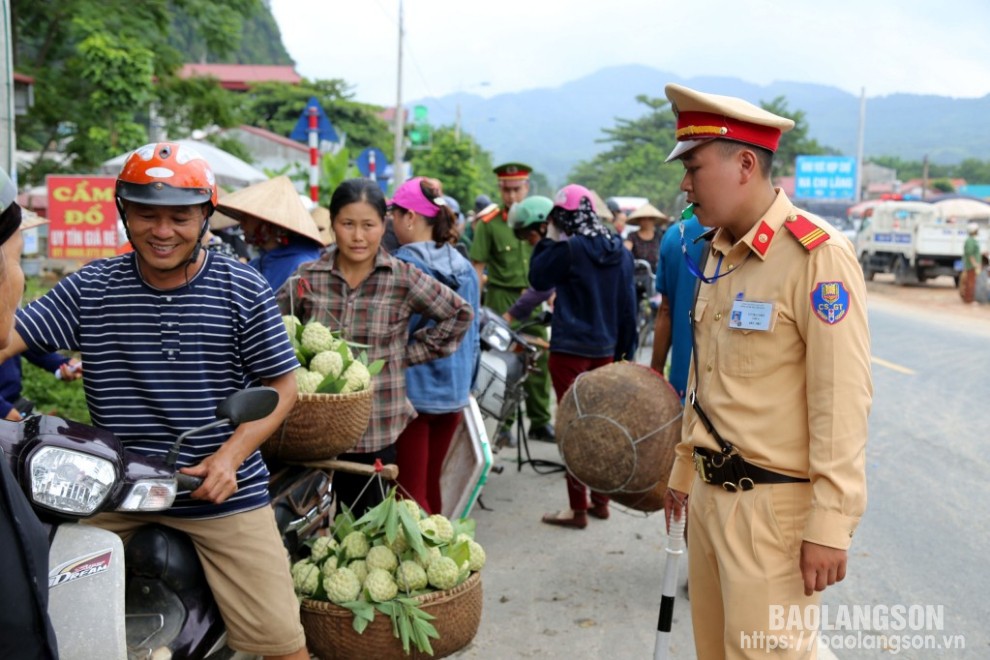 Công an huyện Chi Lăng, nhắc nhở người dân điều khiển xe chở na vào đúng nơi quy định