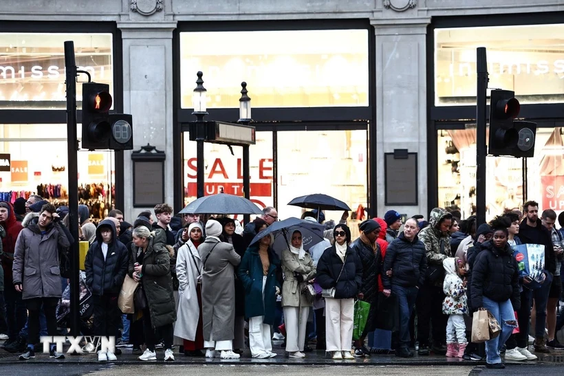 Người dân trên đường phố tại London, Anh. (Ảnh: AFP/TTXVN)