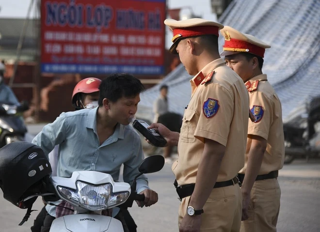 Cảnh sát Giao thông Điện Biên kiểm tra nồng độ cồn người điều khiển phương tiện. (Ảnh: Xuân Tư/TTXVN)