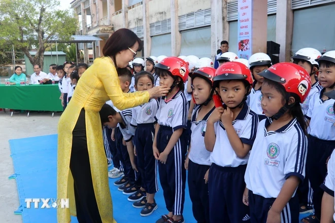 Trao tặng mũ bảo hiểm cho học sinh lớp 1, Trường Tiểu học Nguyễn Hiền, Rạch Giá, Kiên Giang. (Ảnh: Lê Huy Hải/TTXVN)