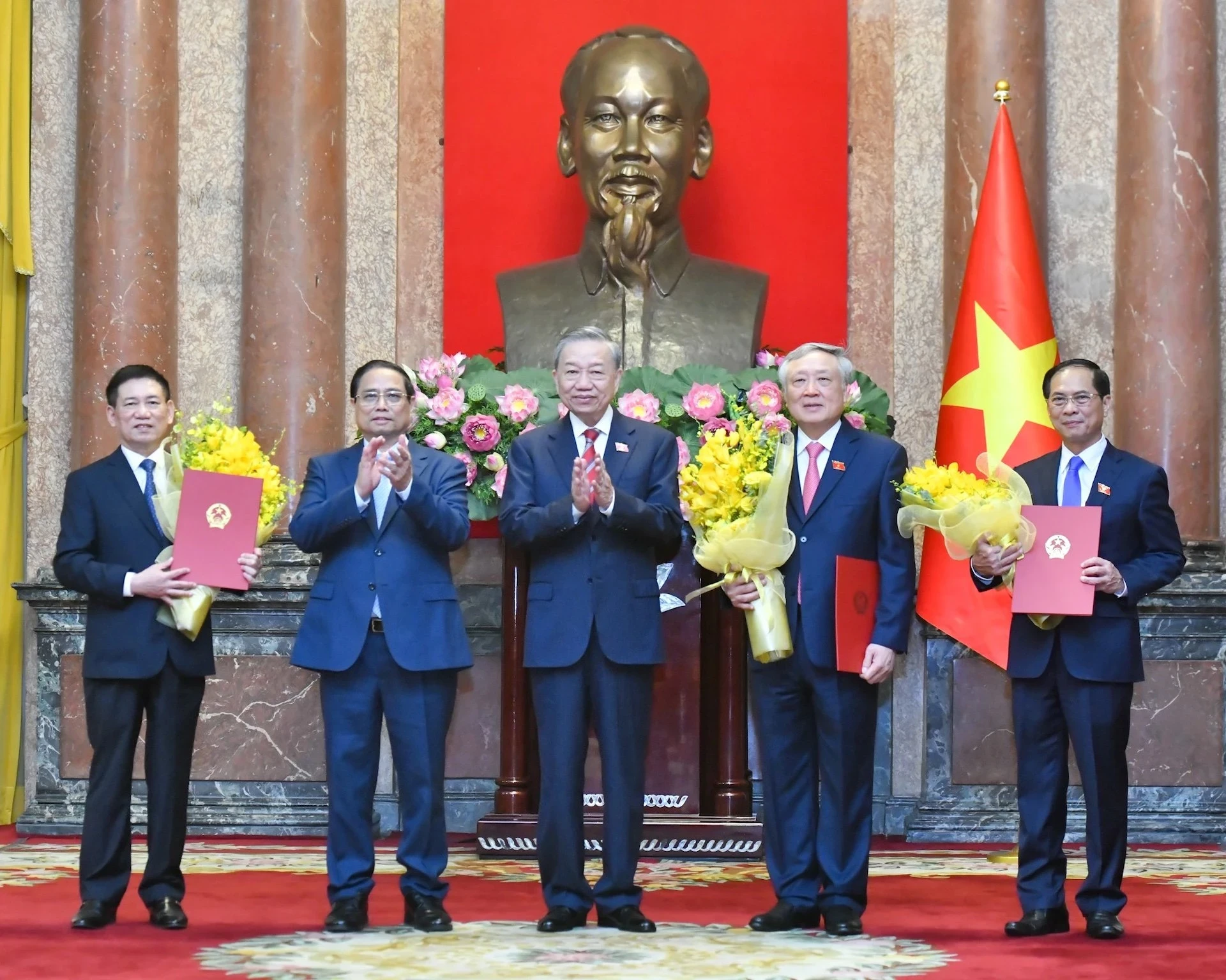 Tổng Bí thư, Chủ tịch nước Tô Lâm trao Quyết định bổ nhiệm, Thủ tướng Phạm Minh Chính tặng hoa chúc mừng các Phó Thủ tướng Nguyễn Hòa Bình, Bùi Thanh Sơn và Hồ Đức Phớc.