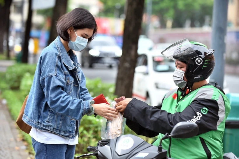 Nhân viên Gojek giao đồ ăn cho khách hàng. (Ảnh: PV/Vietnam+)