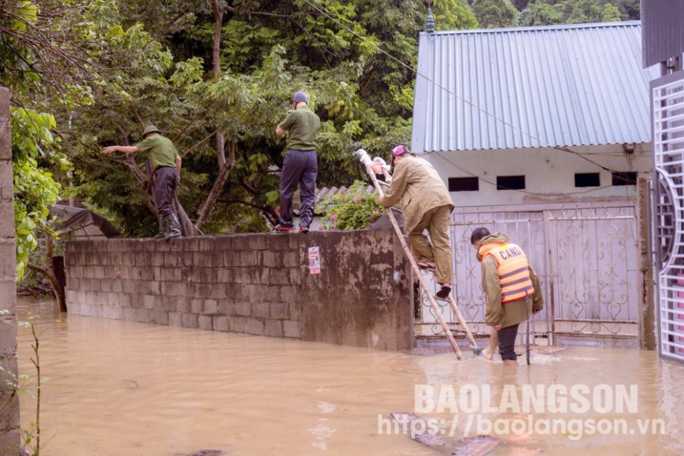 Lực lượng chức năng hỗ trợ dân di dời người và tải sản qua khu vực ngập lụt tại thị trấn Na Sầm, huyện Văn Lãng