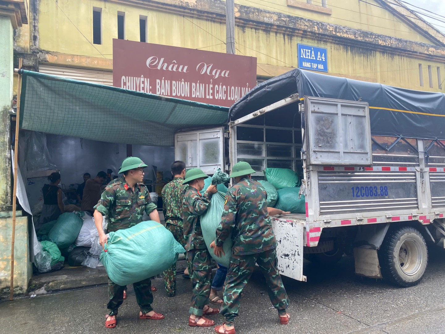 Lực lượng chức năng hỗ trợ các hộ kinh doanh tại chợ Giếng Vuông, thành phố Lạng Sơn di dời hàng hóa ra khỏi khu vực chợ để tránh ngập lụt 