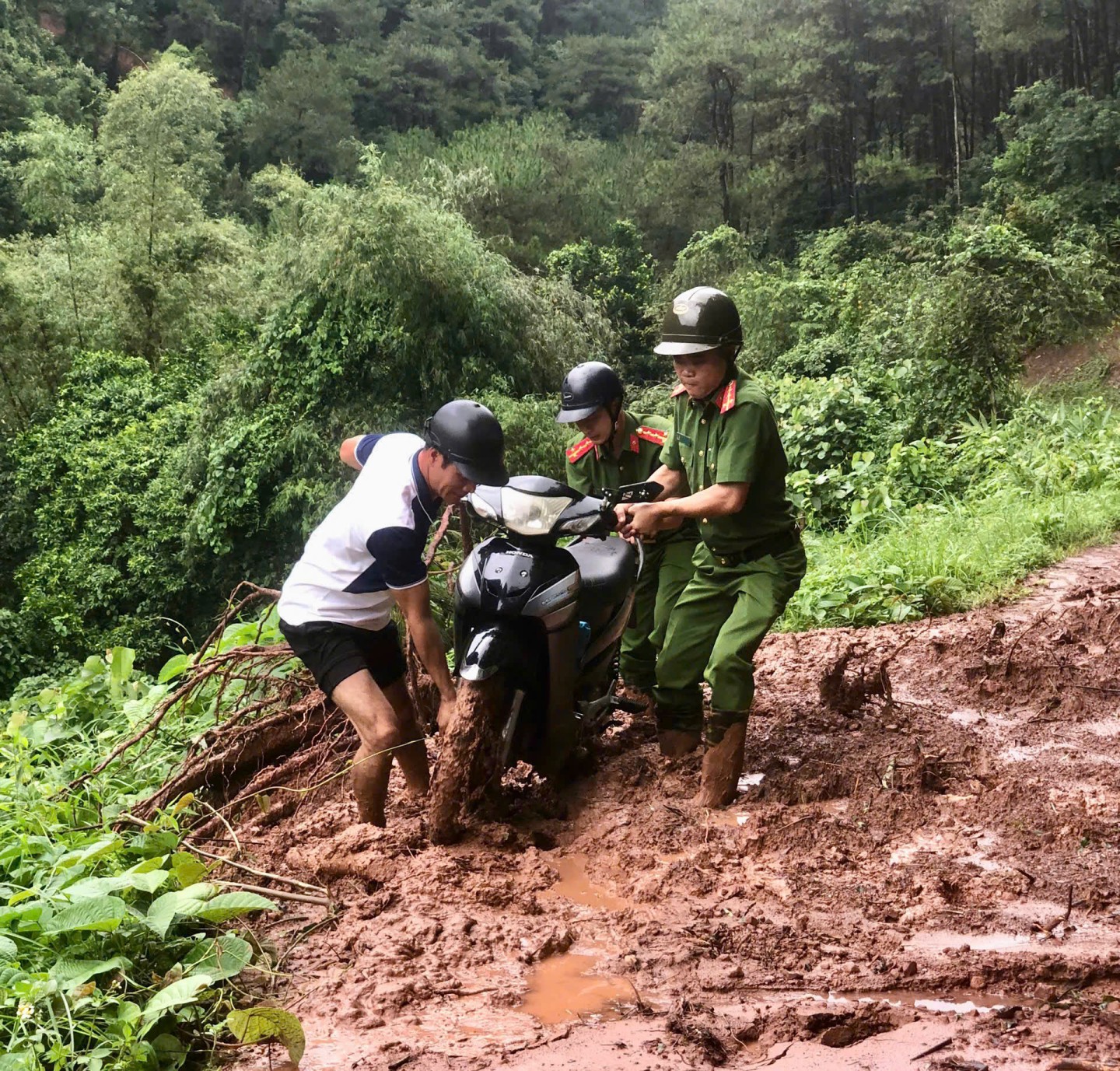 Lực lượng công an huyện Cao Lộc hỗ trợ người dân bị mắc kẹt khi đi qua điểm sạt lở tại thôn Tồng Riền, xã Hải Yến