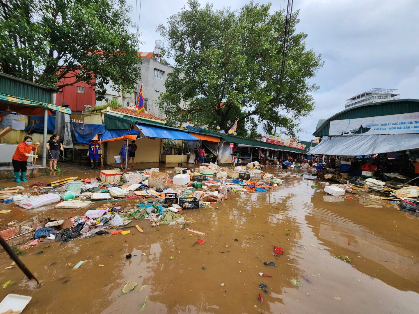 Khi nước bắt đầu rút, các tiểu thương kinh doanh trong chợ Giếng Vuông đã bắt đầu thu gom các loại rác phát sinh tại khu vực chợ