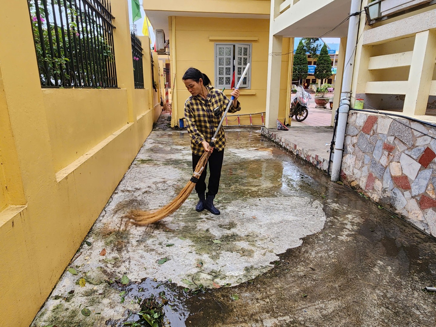 Nhân viên Trường THCS Vĩnh Trại, phường Vĩnh Trại, thành phố Lạng Sơn quét dọn vệ sinh khuôn viên nhà trường sau bão số 3