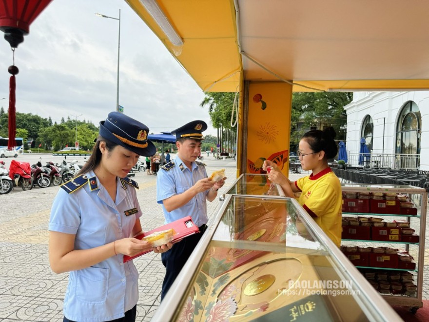 Cán bộ Cục QLTT tỉnh kiểm tra nhãn mác bánh trung thu tại một điểm bán trên đường Hùng Vương, phường Chi Lăng, thành phố Lạng Sơn