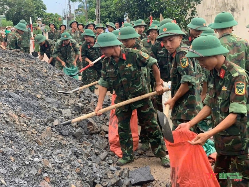  Cán bộ, chiến sĩ Trung đoàn 2 (Sư đoàn 3, Quân khu 1) giúp dân khắc phục hậu quả bão, lũ. 