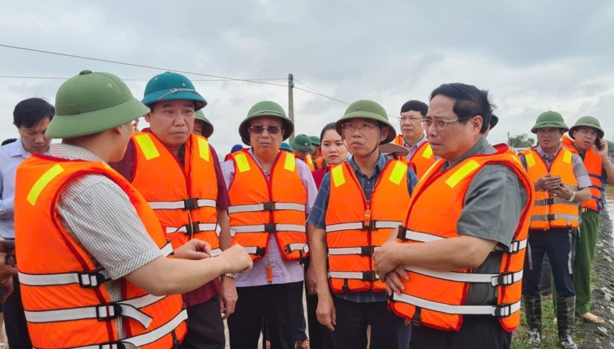 Thủ tướng Phạm Minh Chính nghe báo cáo về công tác phòng, chống lũ tại địa phương. Ảnh: baobacgiang.vn  