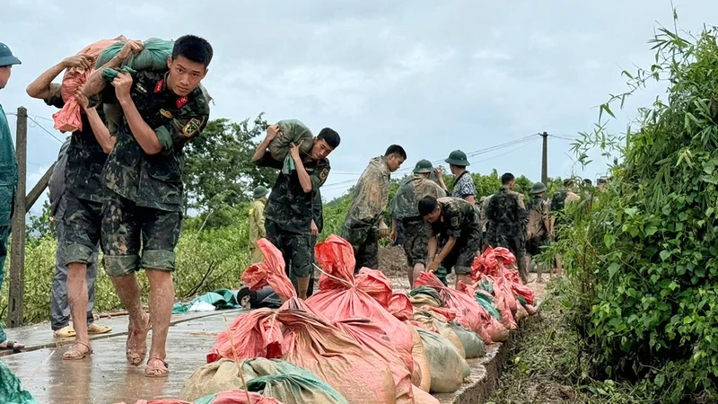 Cán bộ, chiến sĩ tham gia phòng chống sạt lở tại tuyến đê thuộc thôn Mai Tô, xã Phì Ðiền, huyện Lục Ngạn (Bắc Giang). (Ảnh PHẠM THỊNH)