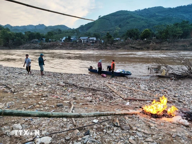 Các nhà hảo tâm di chuyển bằng xuồng đến trao hỗ trợ cho người dân bản Cuông 2. (Ảnh: Phùng Nam Sương/TTXVN)