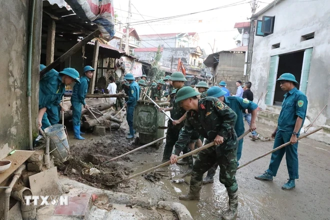 Lực lượng vũ trang, các đoàn thể và nhân dân thị trấn Thất Khê, huyện Tràng Định dọn dẹp rác thải sau mưa lũ (Lạng Sơn). (Ảnh: Văn Đạt/TTXVN)