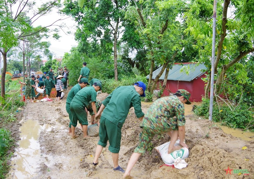 Cán bộ, chiến sĩ Nhà máy Z49 phối hợp với các đơn vị gia cố tuyến đê tại xã Trung Giã.  