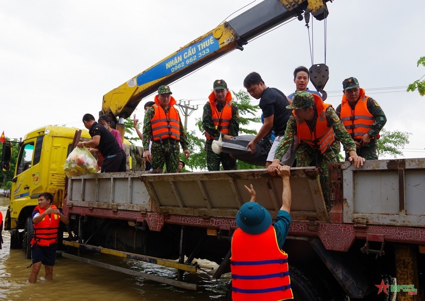 Bộ đội giúp dân di dời tài sản.  