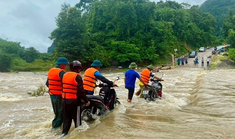 Tổ chức đưa người dân qua tràn nước chảy xiết. Ảnh Văn Trường