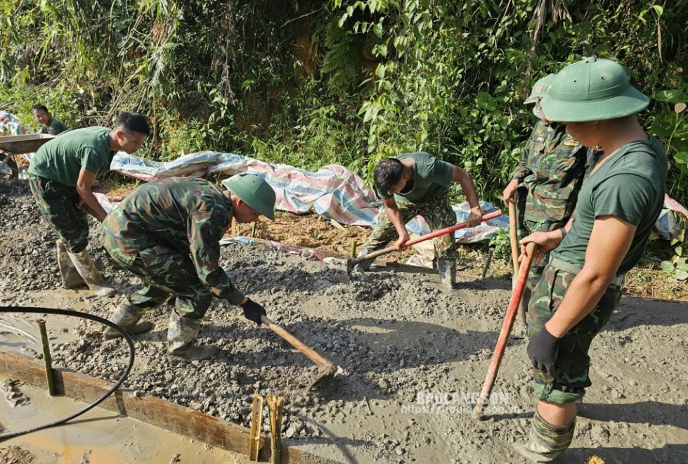 Cán bộ, chiến sĩ Đại đội 1 tham gia làm đường bê tông nông thôn ở xã Hoa Thám, huyện Bình Gia