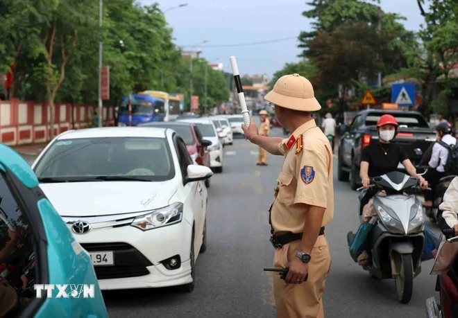 Cảnh sát giao thông phân luồng cho các hướng vào cầu phao Phong Châu. (Ảnh: An Đăng/TTXVN)