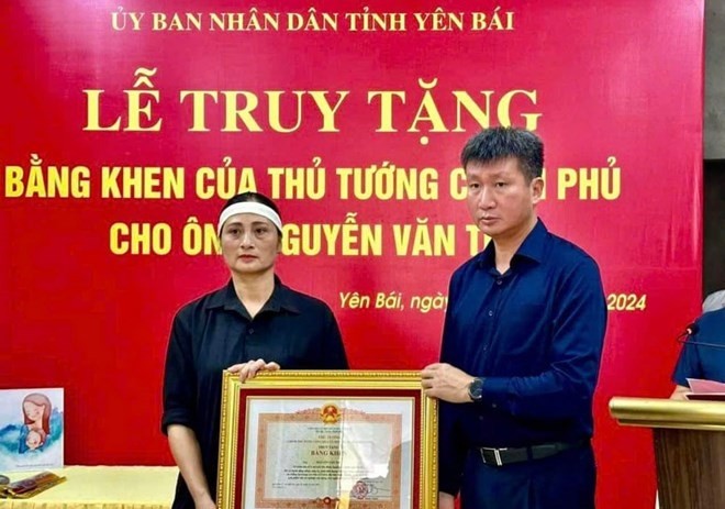 Chủ tịch UBND tỉnh Yên Bái Trần Huy Tuấn trao Bằng khen của Thủ tướng truy tặng ông Nguyễn Văn Thi - người đã hy sinh khi cứu nạn trong bão lũ.