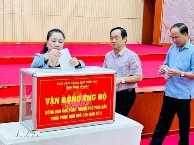 Quyên góp ủng hộ đồng bào các tỉnh, thành miền Bắc khắc phục thiệt hại do bão số 3 thông qua Mặt trận Tổ quốc Việt Nam tỉnh Bình Phước. (Ảnh: TTXVN phát)