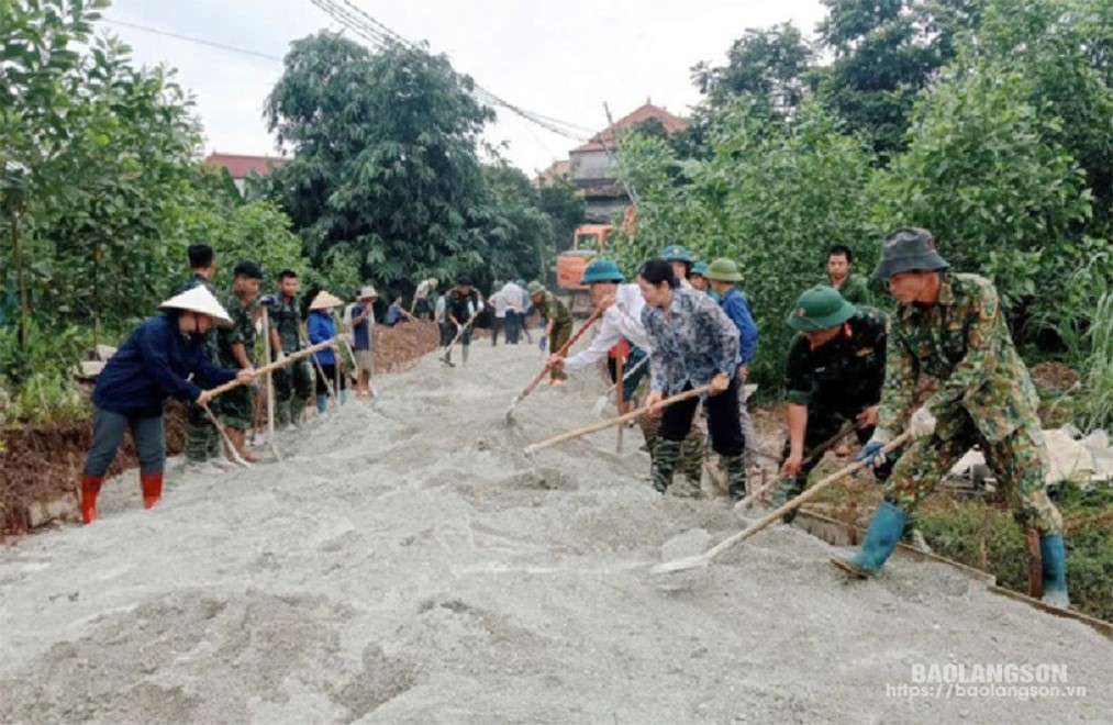 Cán bộ, công chức và cán bộ, chiến sĩ Trung đoàn 123 giúp dân làm đường giao thông nông thôn tại xã Xuân Dương, huyện Lộc Bình