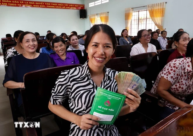 Người dân vui mừng nhận tiền vốn vay từ điểm giao dịch Ngân hàng Chính sách xã hội tỉnh Đồng Nai. (Ảnh: Hồng Đạt/TTXVN)