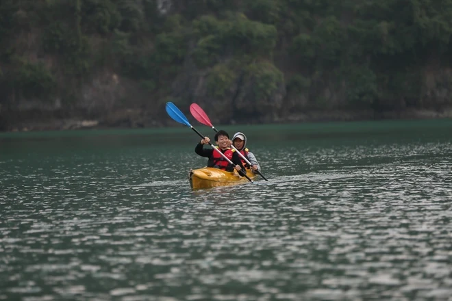 Du khách trải nghiệm chèo thuyền kayak, một trong những hoạt động không thể thiếu trong lòng di sản. (Ảnh: CTV/Vietnam+)