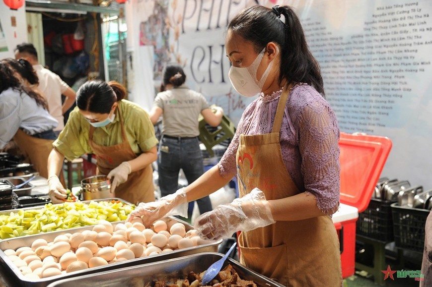 Các tình nguyện viên của nhóm thiện nguyện “Phiên chợ trái tim” tất bật chuẩn bị nguyên liệu, sơ chế đồ ăn. 