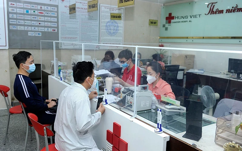 Bệnh nhân và người nhà làm thủ tục thanh toán bảo hiểm y tế tại Bệnh viện Ung bướu Hưng Việt (Hà Nội). (Ảnh NGUYỄN ĐĂNG)