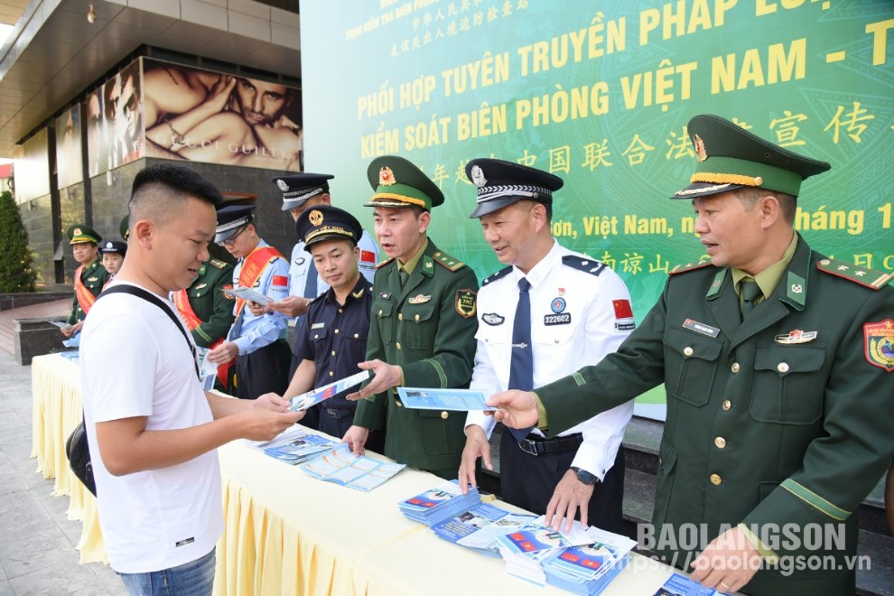 Lực lượng chức năng hai bên phát tờ rơi, trực tiếp tuyên truyền cho người dân qua lại cửa khẩu hai bên