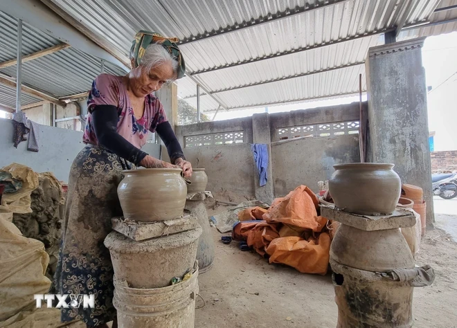 Nghệ nhân lớn tuổi người Chăm làm gốm. (Ảnh: Nguyễn Thành/TTXVN)