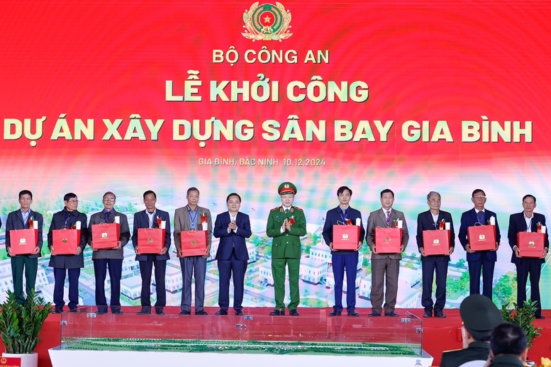 Lãnh đạo tỉnh Bắc Ninh và Bộ Công an tặng quà cho các hộ gia đình nhường đất cho dự án - Ảnh: VGP/Nhật Bắc