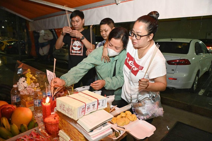 Người thân thắp nén nhang cho nạn nhân ở Singapore. (Ảnh: Straits Times)