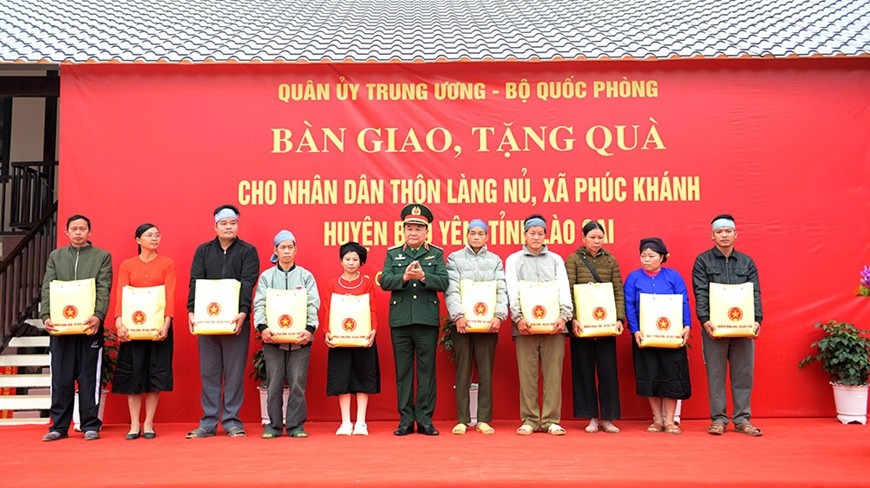 Thượng tướng Hoàng Xuân Chiến trao quà của Quân ủy Trung ương, Bộ Quốc phòng tặng bà con thôn Làng Nủ. 