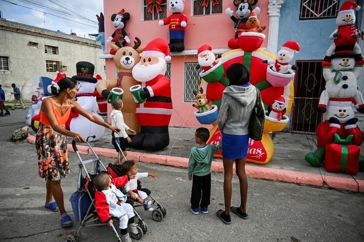 Người lớn và trẻ em ngắm nhìn ngôi nhà trang trí bằng Ông già Noel tại thủ đô Havana của Cuba. (Ảnh: Getty)