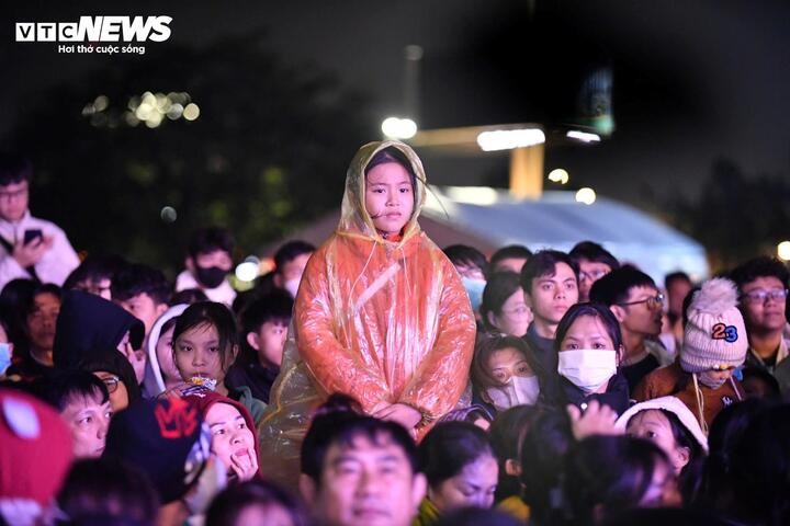 Trẻ em cũng được gia đình đội mưa, chen chân đưa đến quảng trường để tham gia lễ hội.