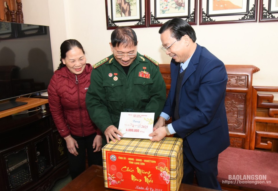 Đồng chí Hoàng Văn Nghiệm, Bí thư Tỉnh ủy, Trưởng Đoàn Đại biểu Quốc hội tỉnh trao quà cho Đại tá Nông Văn Phiao, Anh hùng lực lượng vũ trang nhân dân