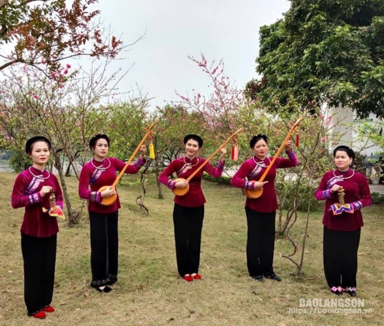 Thành viên Câu lạc bộ Nộc Khảm khắc (huyện Văn Lãng) trình diễn hát then tại vườn đào khu vực Công viên Chi Lăng (thành phố Lạng Sơn)