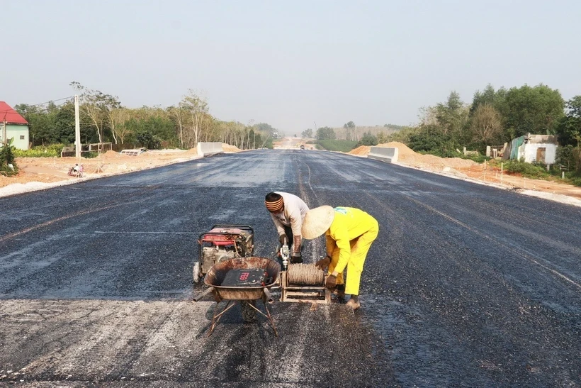 Công nhân chuẩn bị cho việc thảm nhựa mặt đường cao tốc Vạn Ninh-Cam Lộ vào dịp giáp Tết đoạn qua huyện Vĩnh Linh, tỉnh Quảng Trị. (Ảnh: Nguyên Lý/TTXVN)