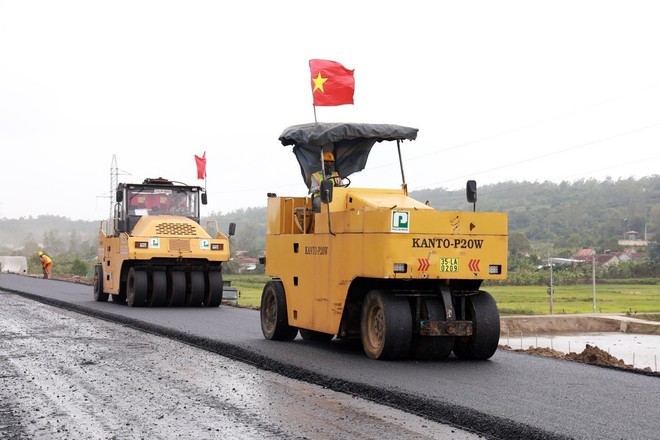 Nhà thầu thi công thảm nhựa mặt đường cao tốc tại dự án thành phần Chí Thạnh-Vân Phong. (Ảnh: Xuân Triệu/TTXVN)