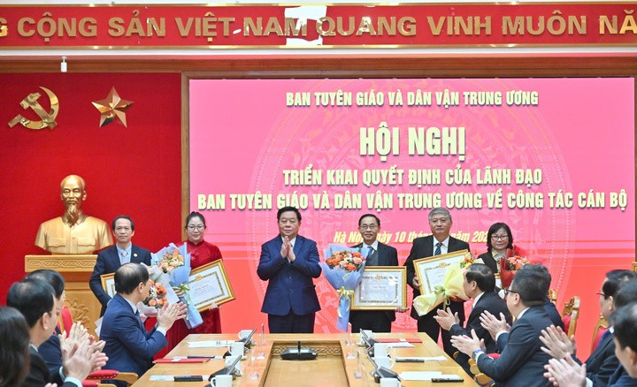 Trưởng ban Tuyên giáo và Dân vận Trung ương Nguyễn Trọng Nghĩa trao bằng khen, tặng hoa chúc mừng các cán bộ xin nghỉ hưu trước tuổi. (Ảnh: Trần Vương)