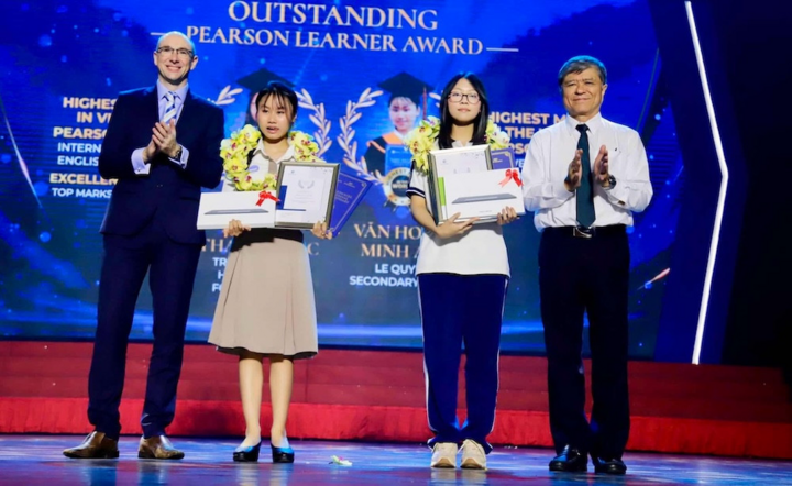 Văn Hoàng Minh Anh (thứ hai từ bên trái) và Trần Hà Thanh Trúc (thứ hai từ bên phải) được trao chứng chỉ Pearson Edexcel.